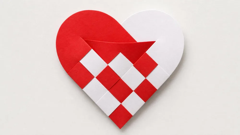 Woven red-and-white checkerboard paper heart forming a small pocket.