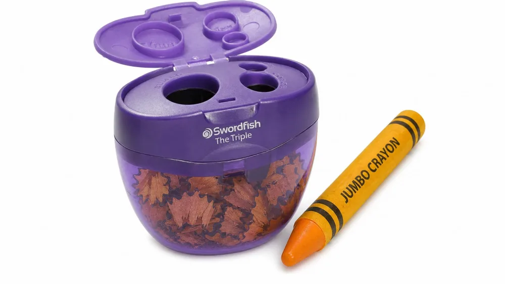 A Swordfish Triple canister sharpener with a fat jumbo crayon in its largest 16 mm hole, shavings visible inside the barrel.