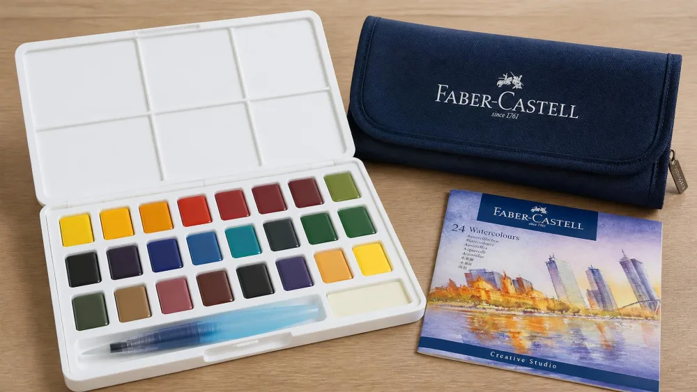 A Faber-Castell Creative Studio 24-color palette open on a table with its water brush and travel bag.