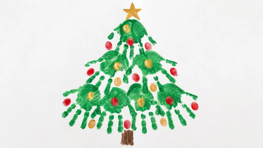 Green-painted handprints stacked into a Christmas tree on white paper, with red and gold fingerprint ornaments.