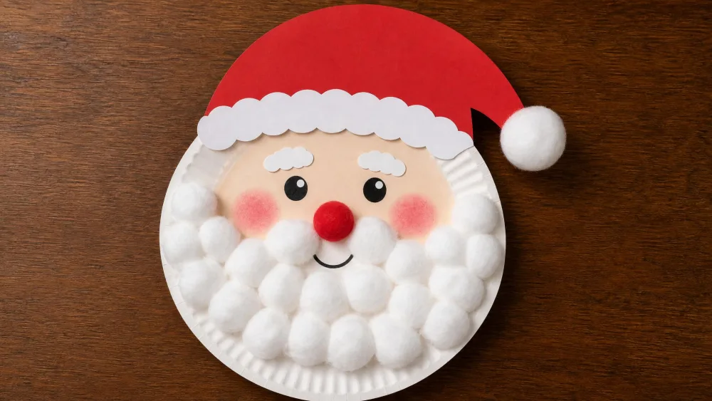 A paper plate decorated as Santa with a cotton-ball beard, rosy cheeks, and a red paper hat.