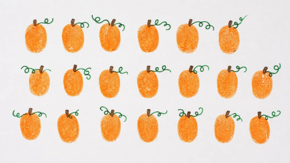 Rows of small orange thumbprint pumpkins with green marker vines on white paper.
