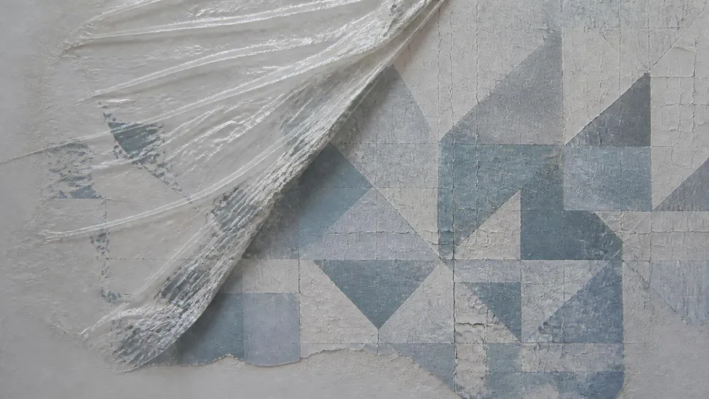 Plastic wrap peeled off a wash revealing crackled geometric texture.