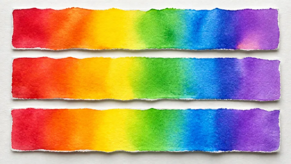 Three paper strips painted in blended rainbow watercolor bands.