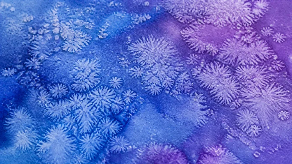 Coarse salt sprinkled over a wet blue and purple wash, forming pale starburst textures.