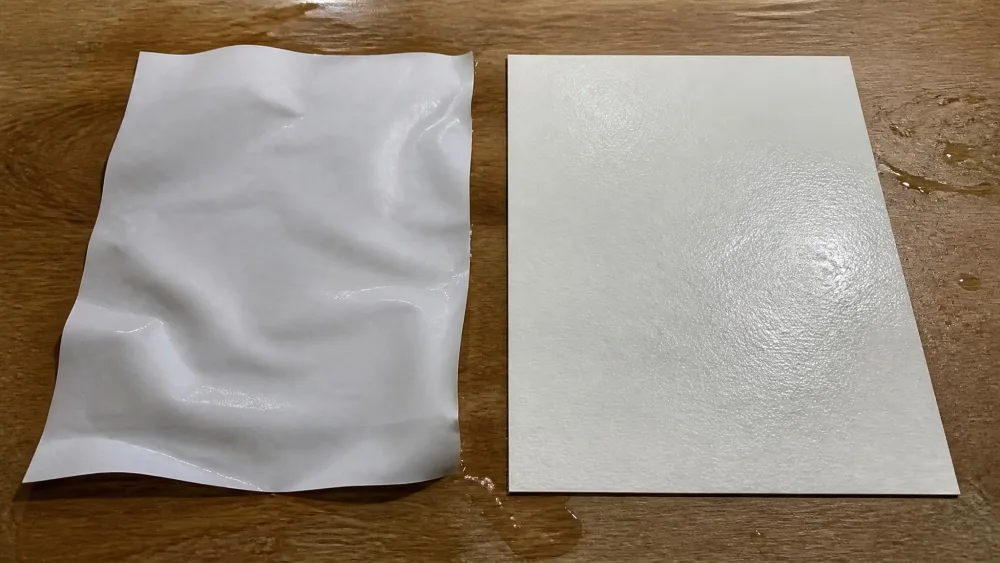 Two wet sheets side by side: buckled printer paper next to flat watercolor paper.