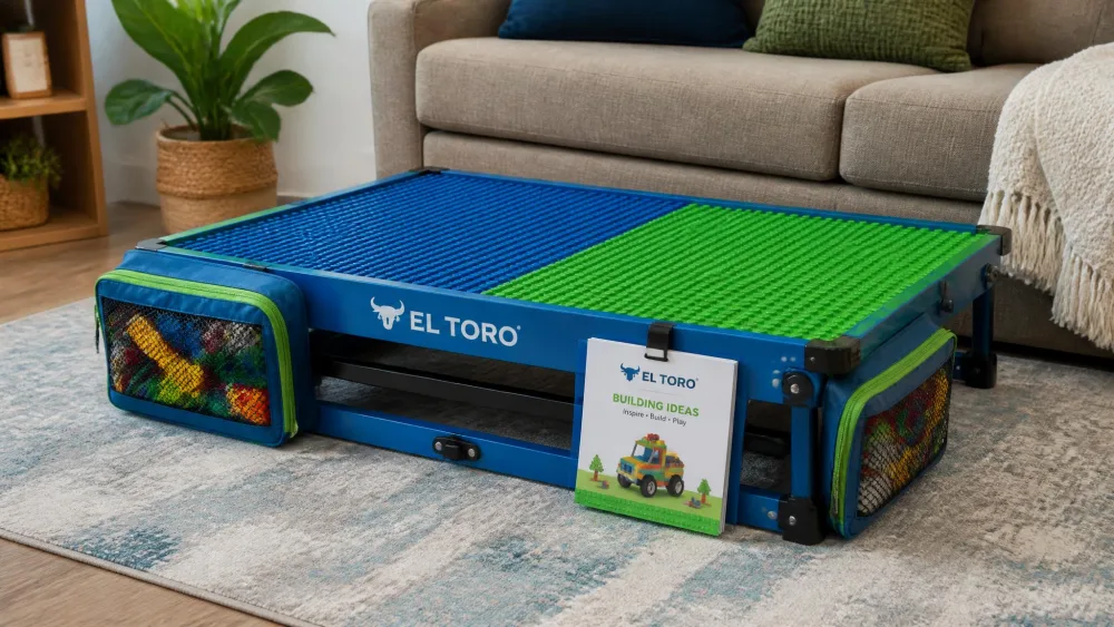 A blue and green grid-topped El Toro foldable block table beside a sofa with its legs folded flat, zippered side pouches full of bricks and a booklet clipped to the frame.