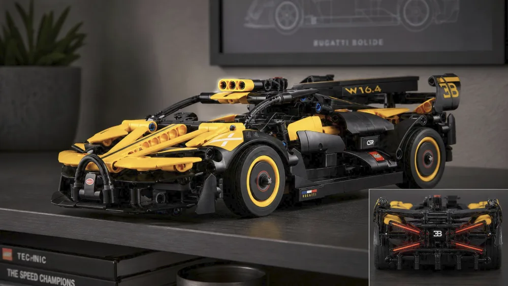 The built LEGO Technic 42151 Bugatti Bolide in black and yellow on a shelf, showing the horseshoe grille and X-shaped tail-lights.